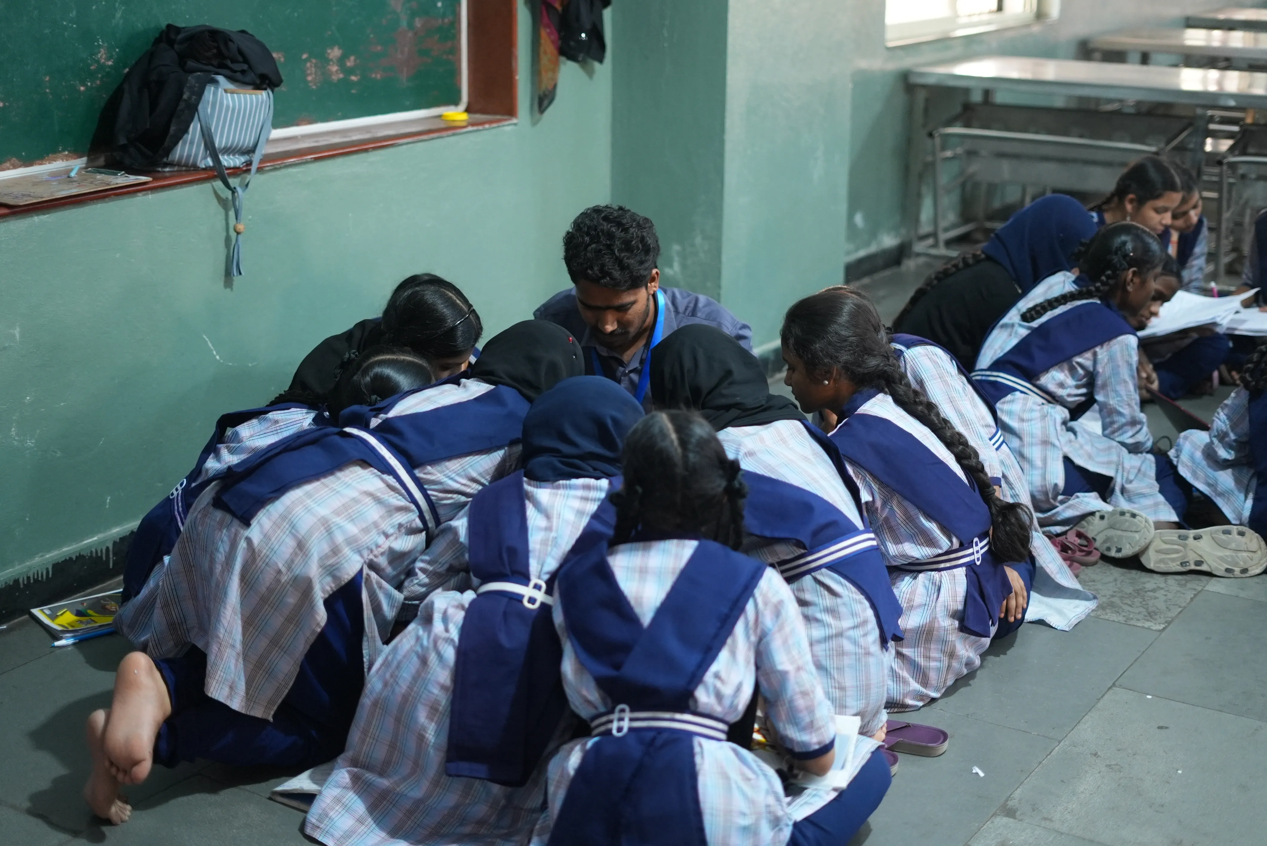 Rocky sitting on the floor with students during a hands-on session